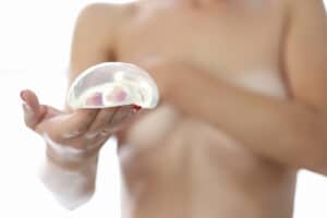 mujer desnuda tiene implante mamario mano